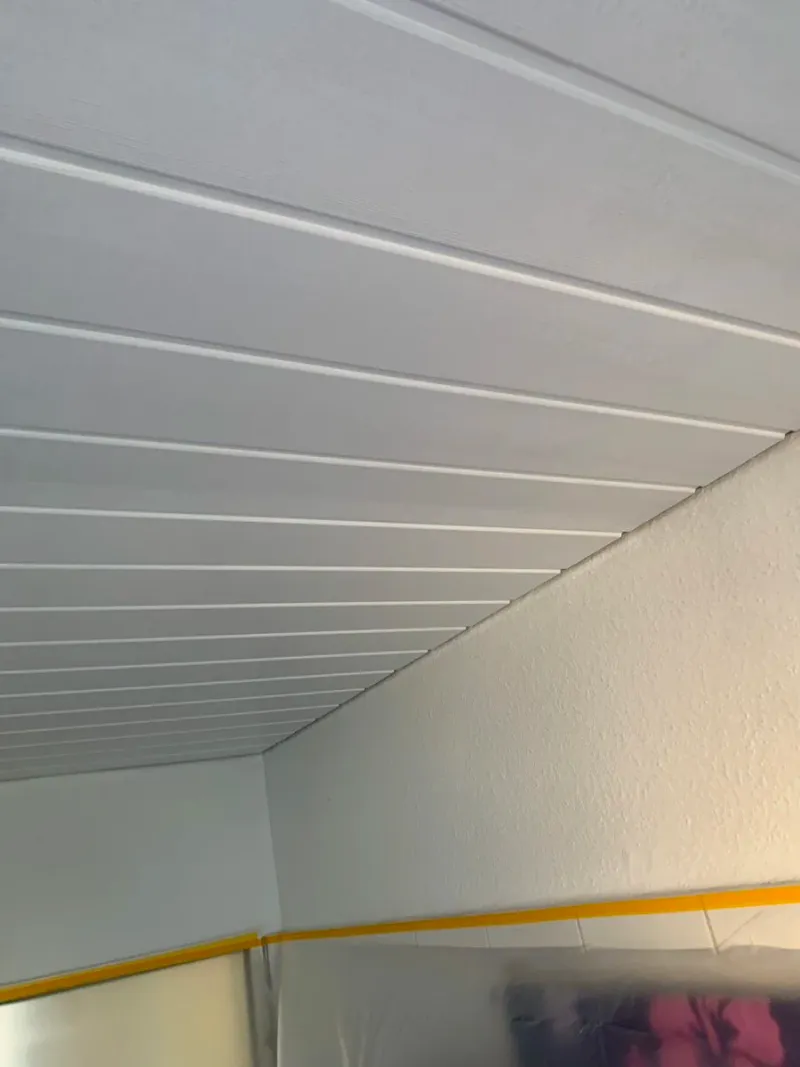 Weiß gestrichene Deckenpaneele in einem Innenraum