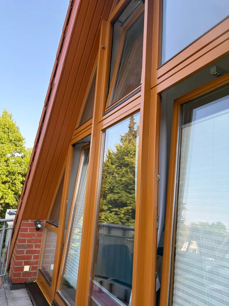 Lasierte Holzfenster und Holzverschalung an einer Hausfassade
